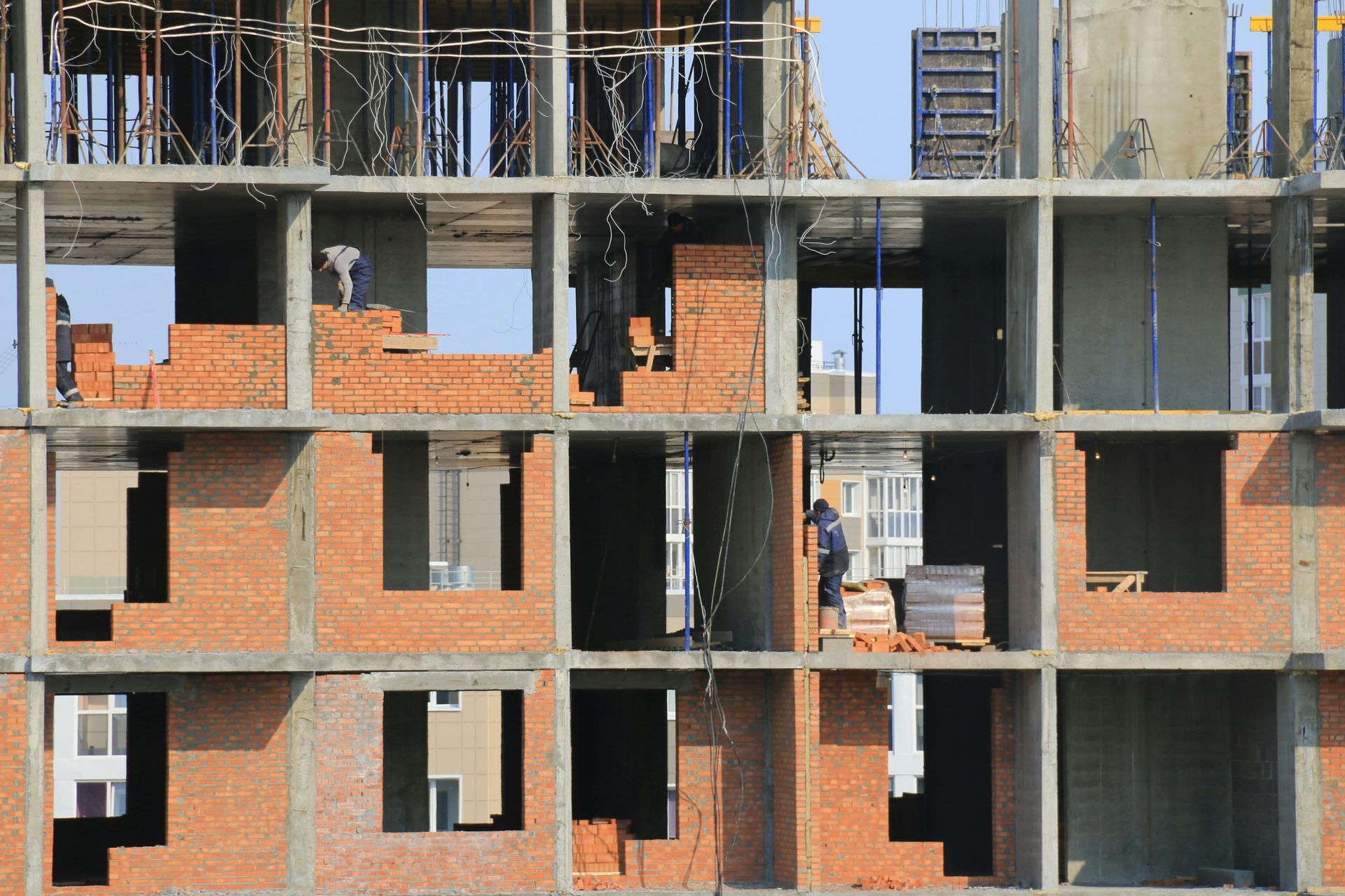 Partially built brick apartment building with exposed concrete floors and open window frames