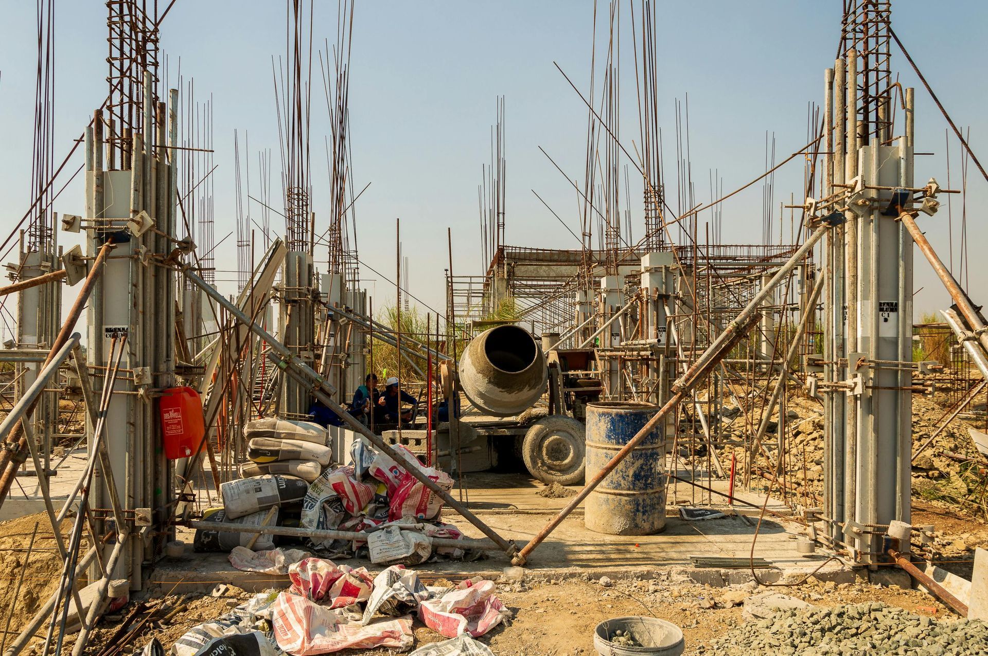 Construction site with scaffolding and rebar framing around concrete columns