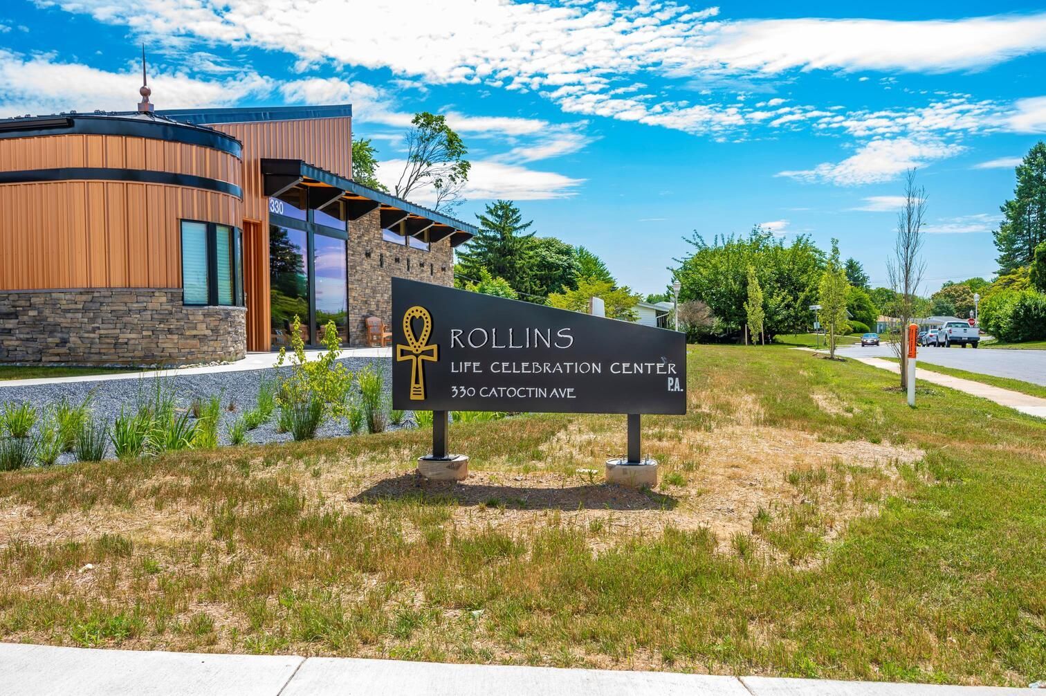 Rollins college sign outside a modern brick building on a sunny campus