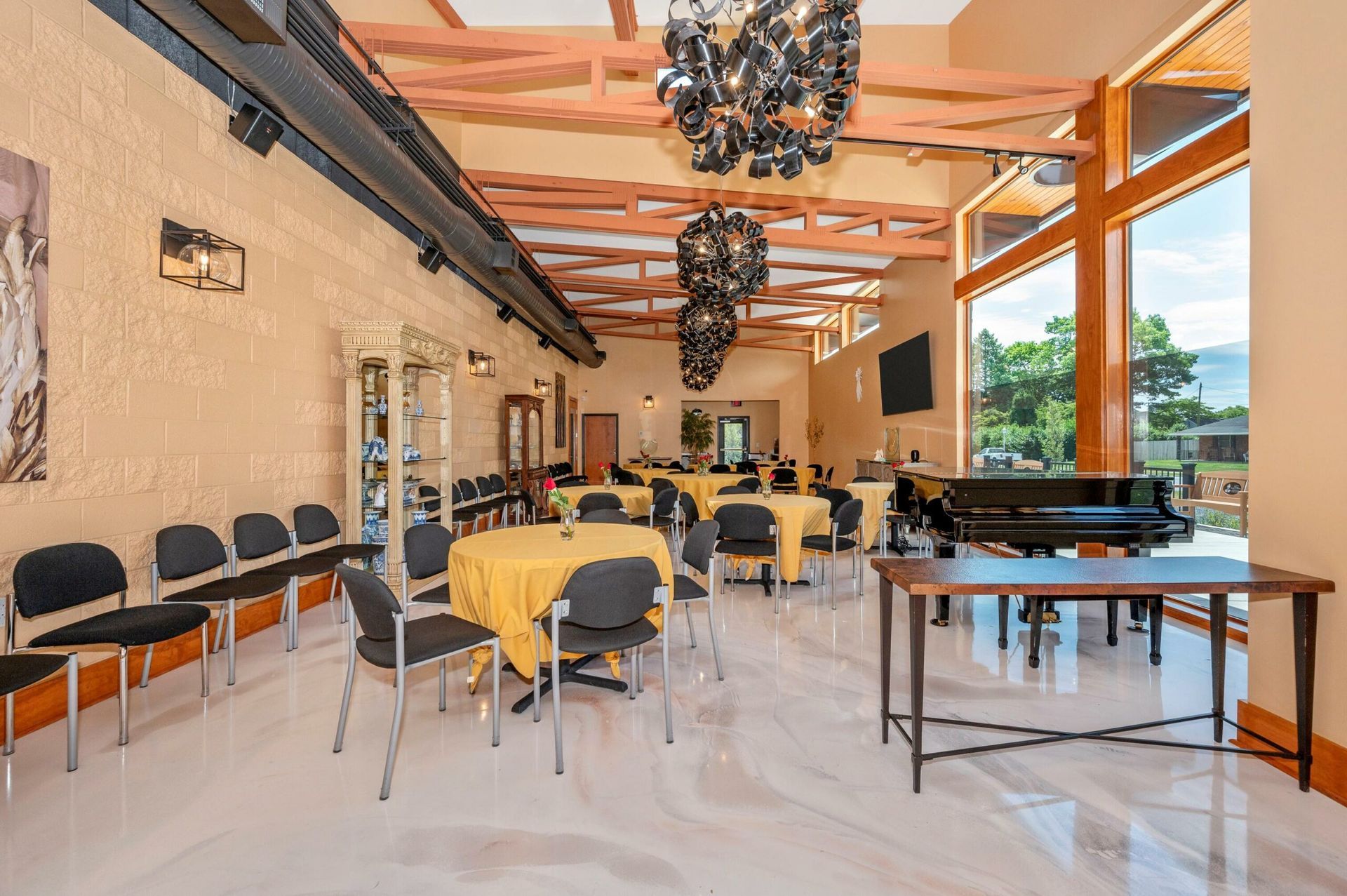 Modern indoor dining hall with tables, chairs, marble floor, and hanging lights