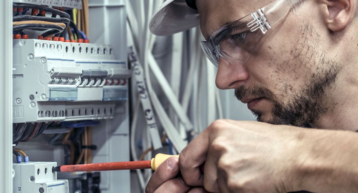 Electrician from Little Red Acorn working on an electrical outlet