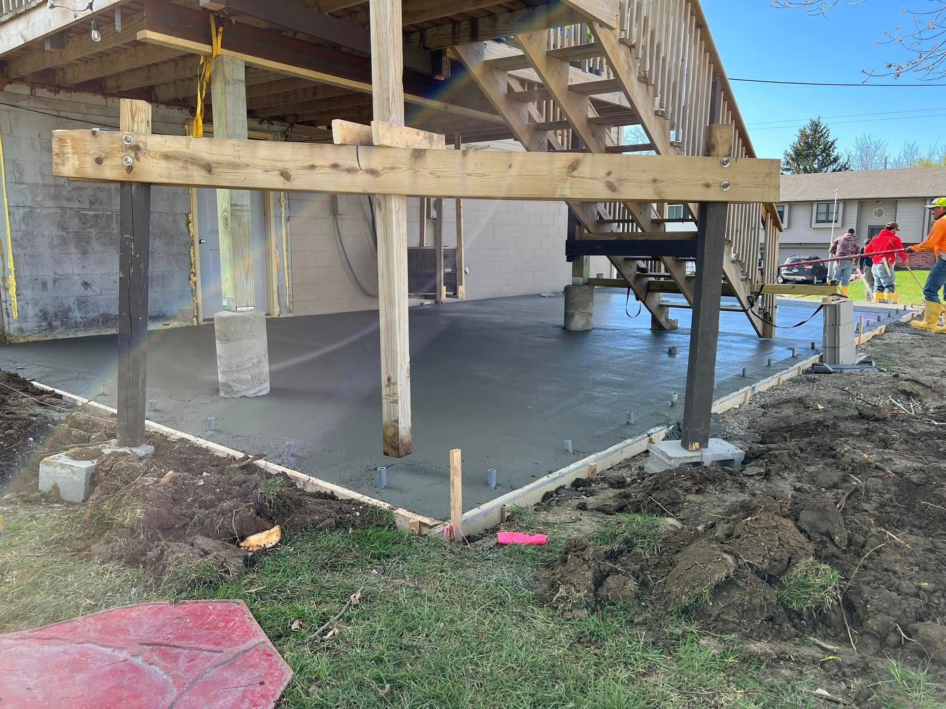 A concrete deck is being built under a house.