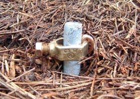 Grounding rod with clamp in soil.
