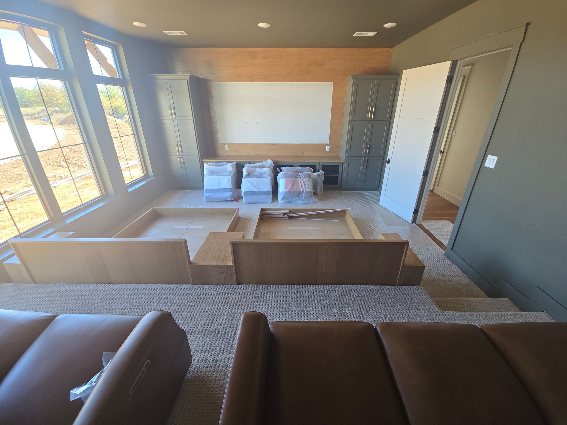 Modern living room with large windows, gray walls, and staged furniture in an open, bright interior.