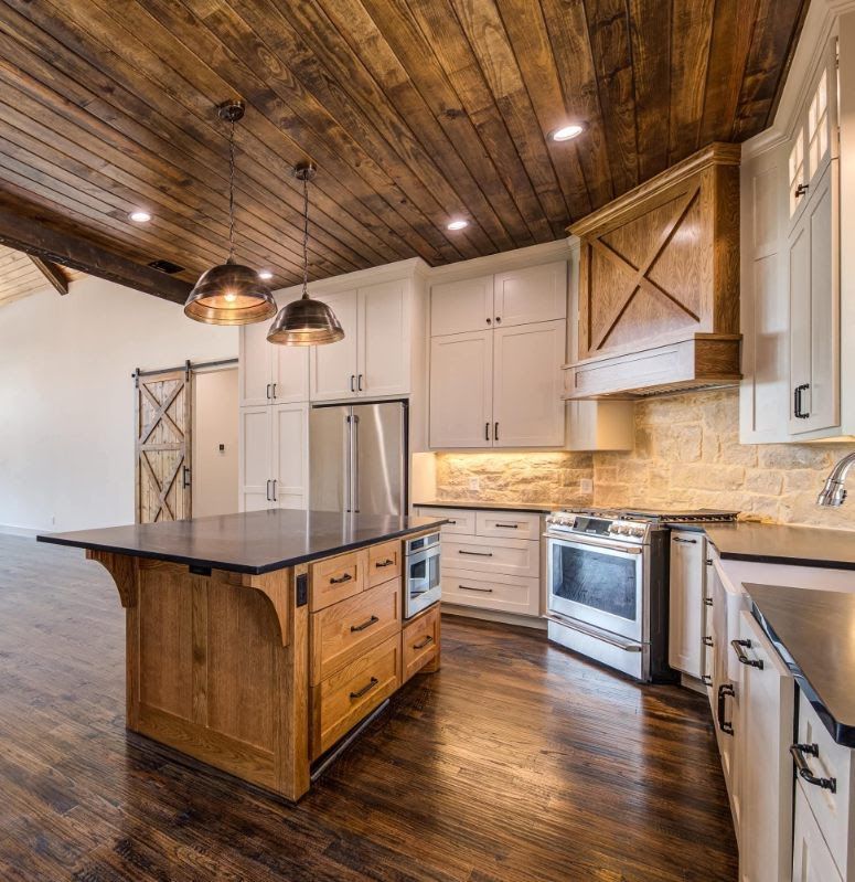 Rustic modern kitchen with wood ceiling, island, stainless appliances, and dark wood floors