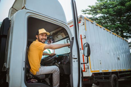 a man is sitting in the driver 's seat of a truck .