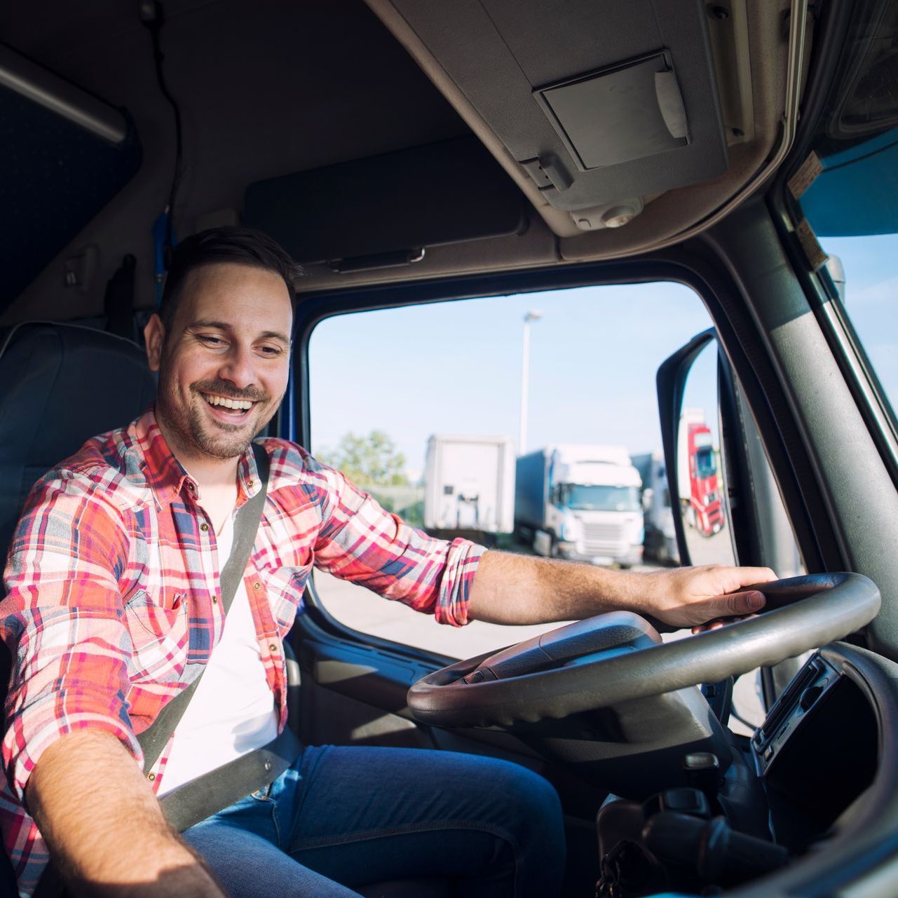 a man is sitting in the driver 's seat of a truck .