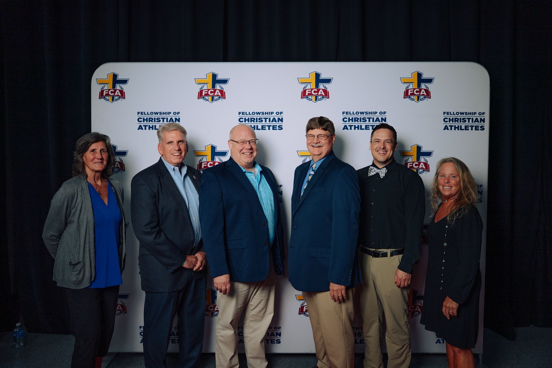 Six Battlefield FCA team members standing together in front of an FCA backdrop.