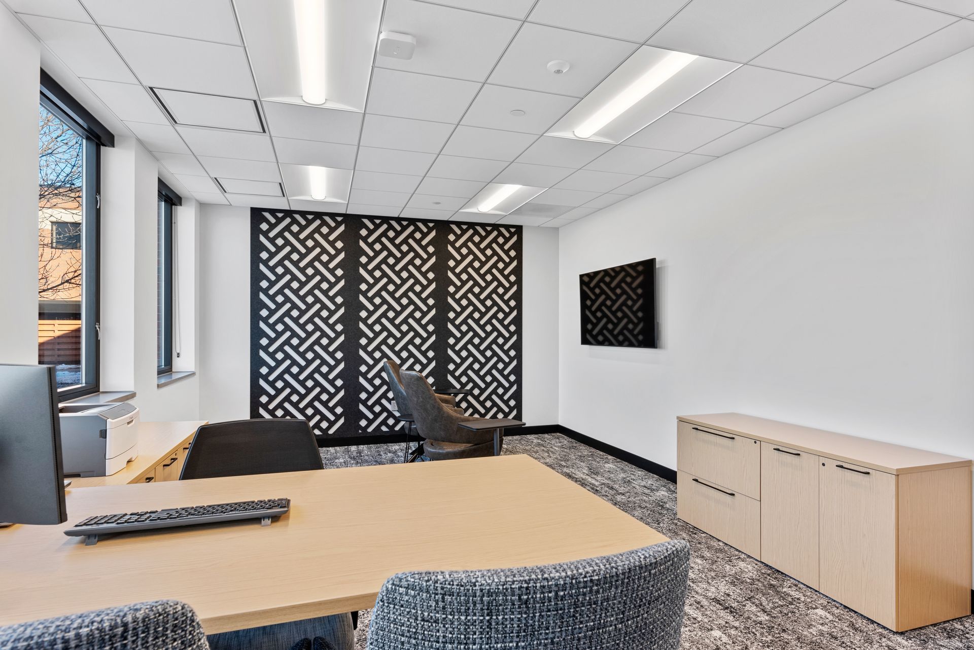 Office interior with desk, patterned screen, and modern decor.