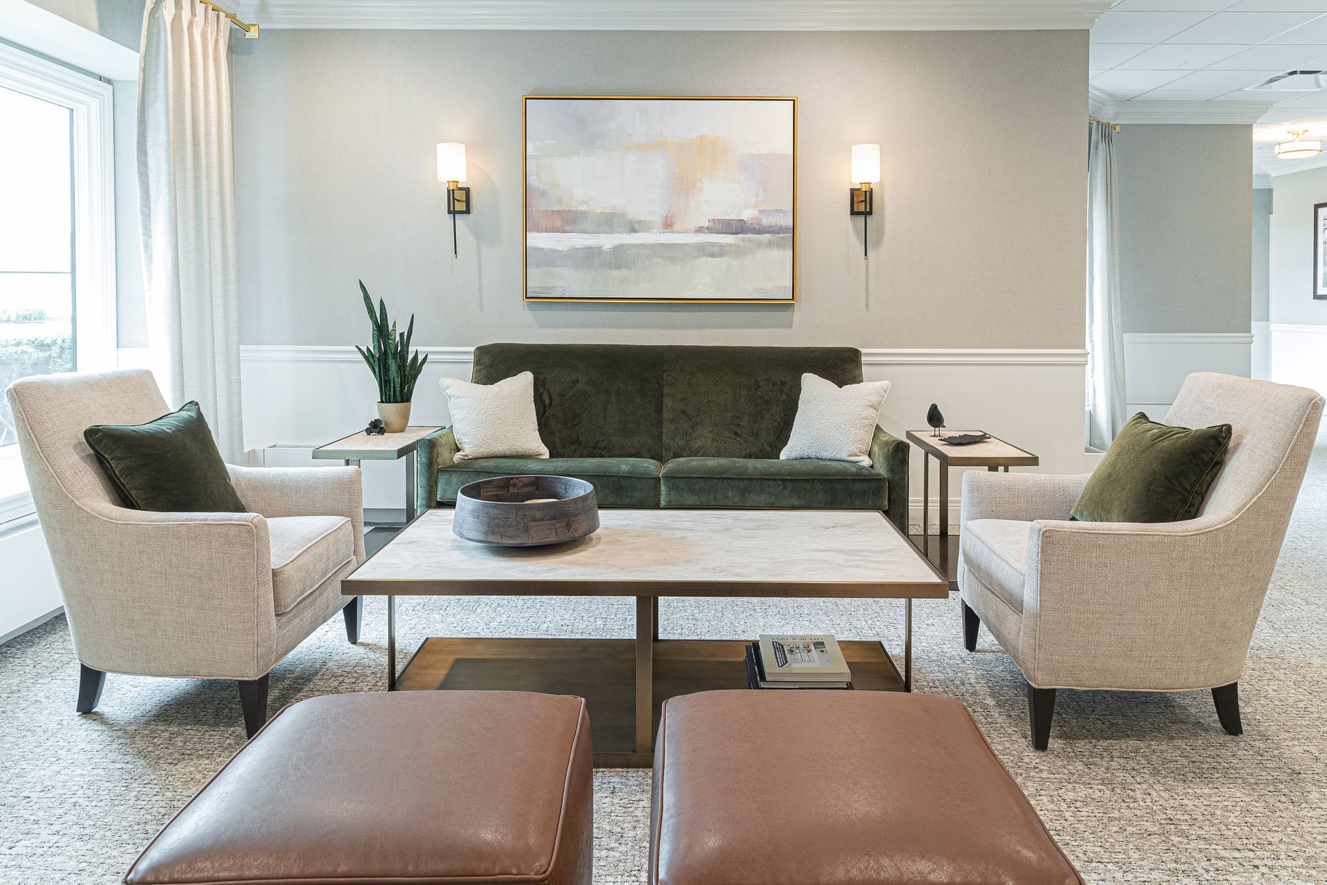 Living room with green velvet sofa, cream armchairs, coffee table, and painting.