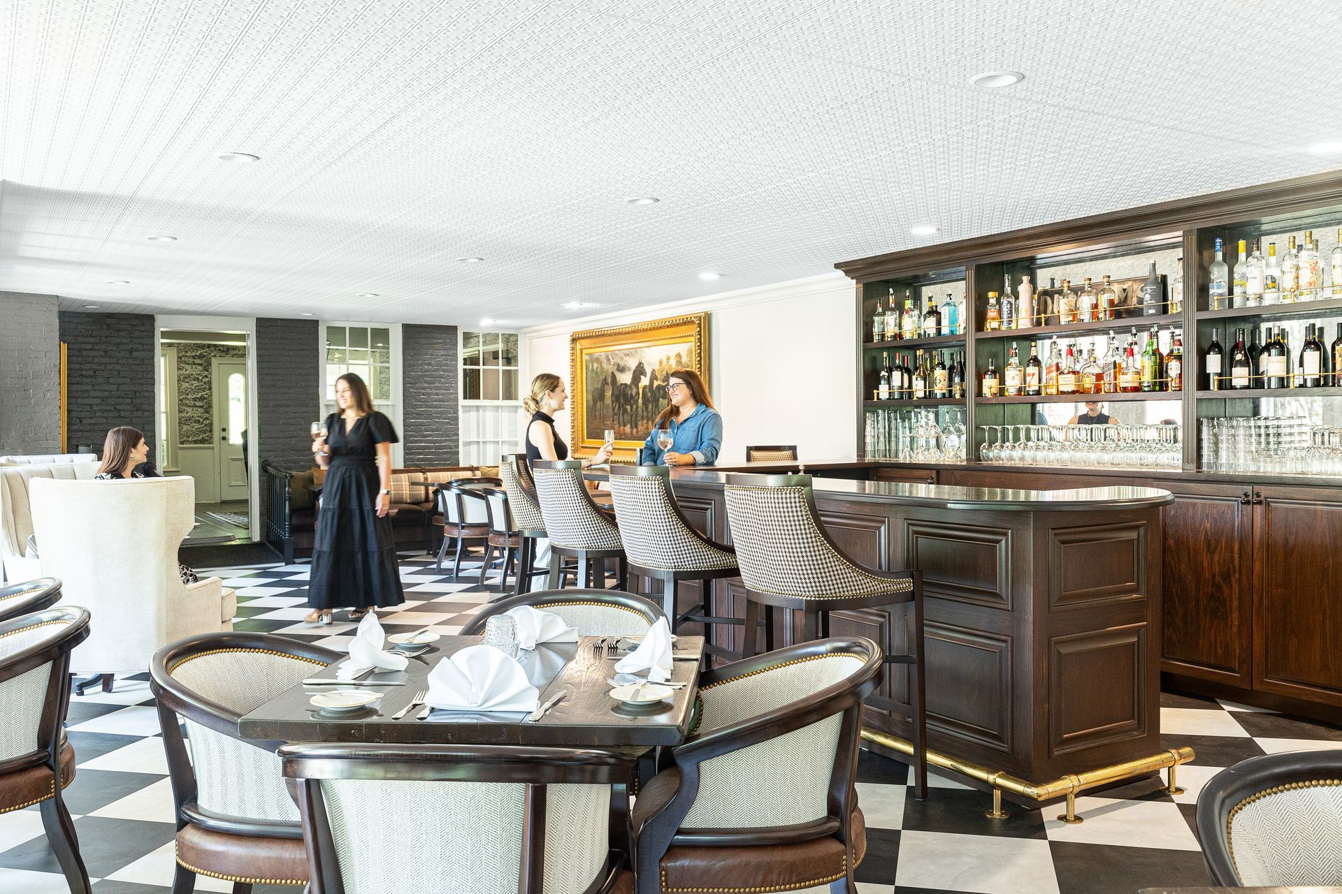 Restaurant interior with checkered floor, bar with liquor bottles, and patrons.