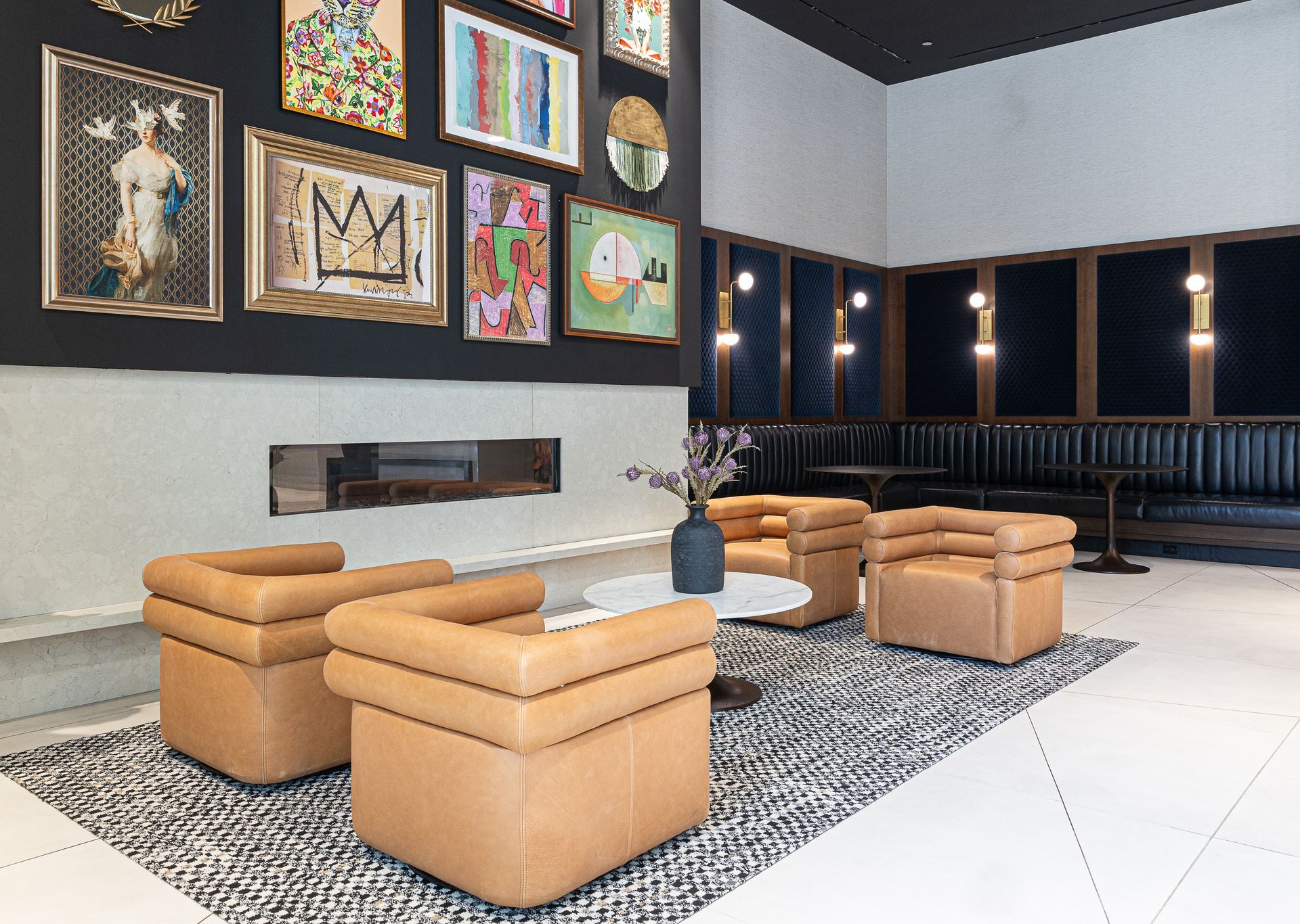 Cozy lounge with tan leather chairs, fireplace, artwork, and banquette seating.