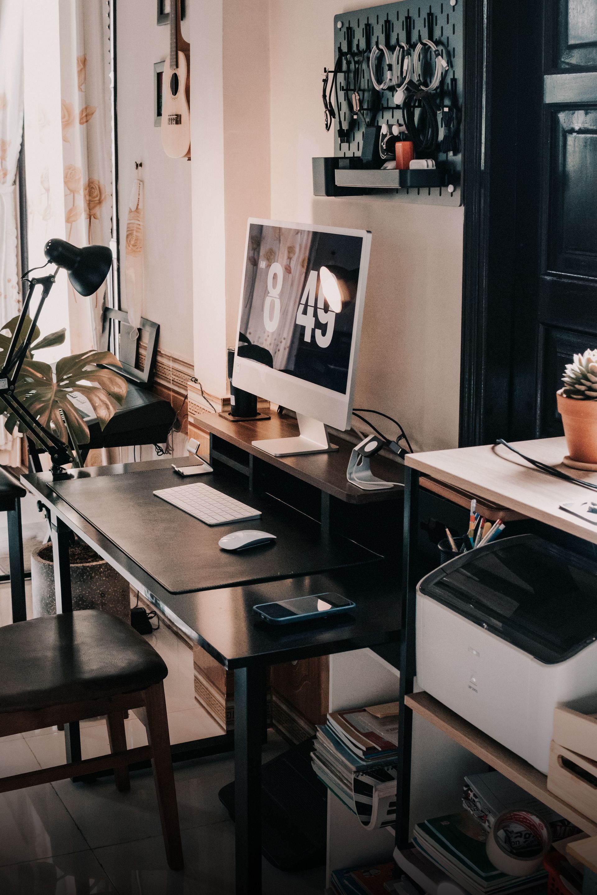 Modern home office with a desk, dual monitors, shelves, and a bicycle by the window