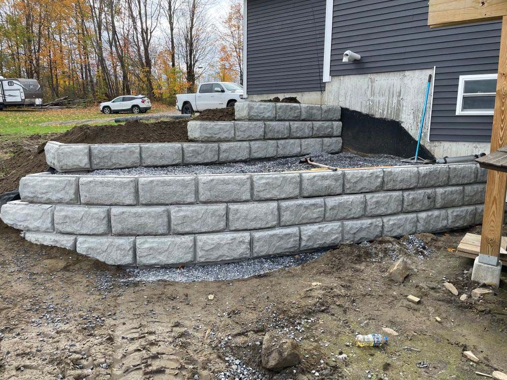 A brick wall is being built in front of a house.