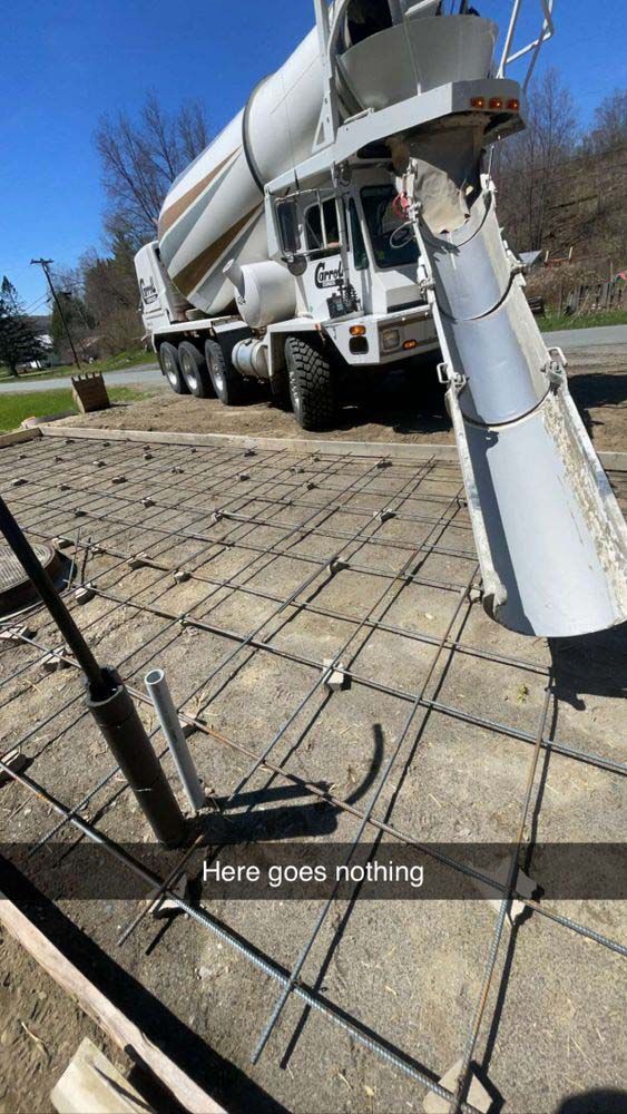 A concrete mixer truck is pouring concrete into a concrete slab.