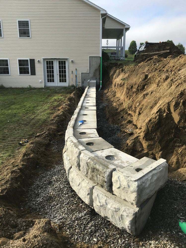 A concrete wall is being built in front of a house.