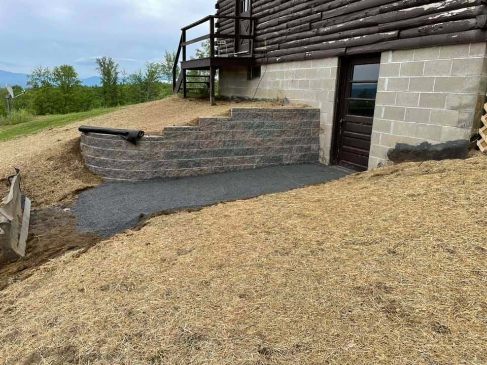 A brick wall is being built in front of a house.