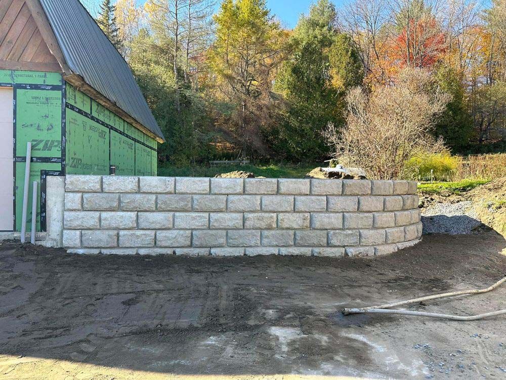 A brick wall is being built in front of a house.