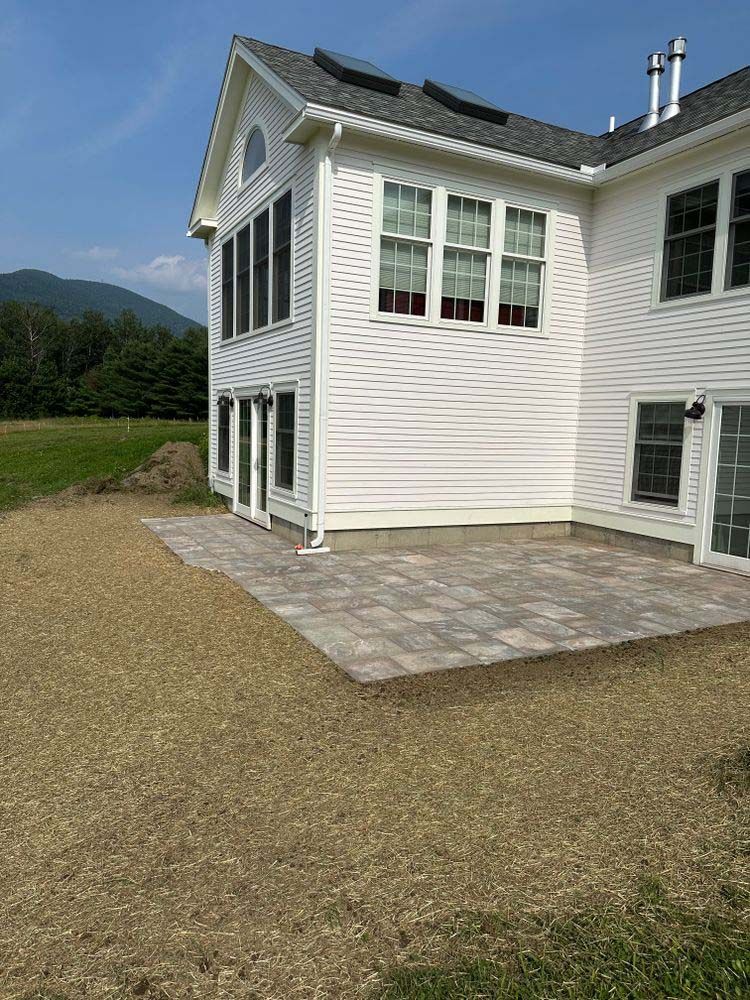 A large white house with a patio in front of it.