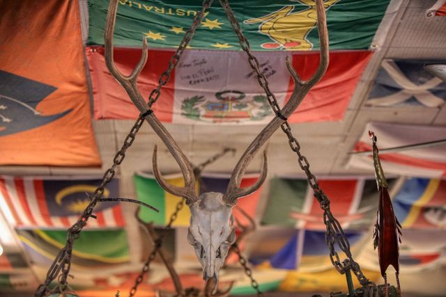 Hanging skull and chains in front of colorful flags, creating a macabre decorative display