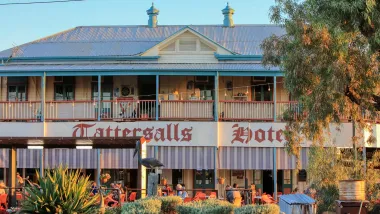 Facade of the Cattersalls Hotel with blue roof, white balcony, and flowers in front