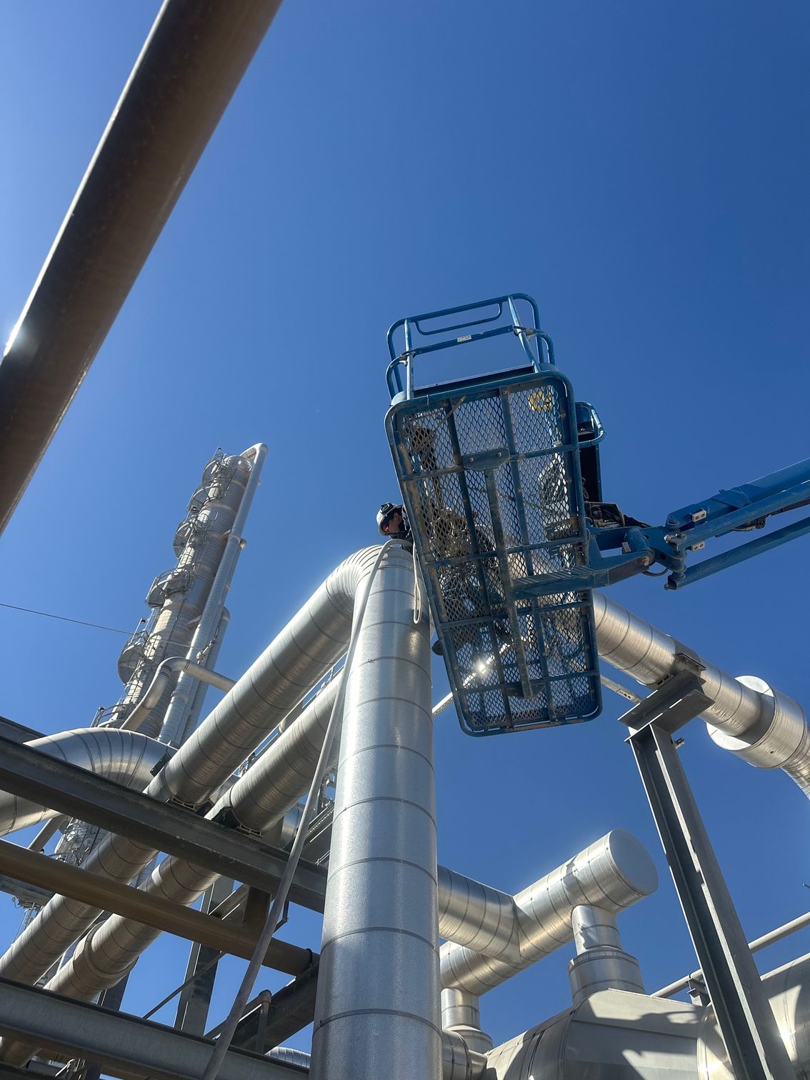 A man is working on a pipe with a crane.