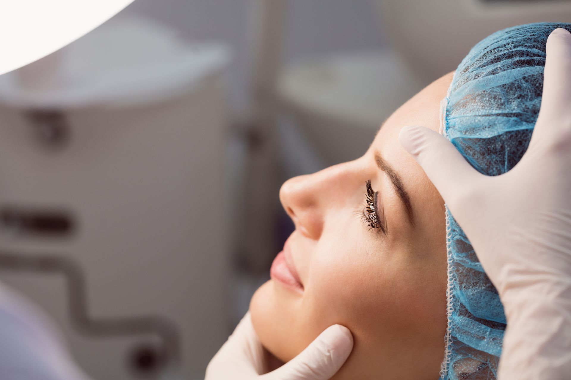 Doctor is examining the facial plastic procedure he completed on a woman.