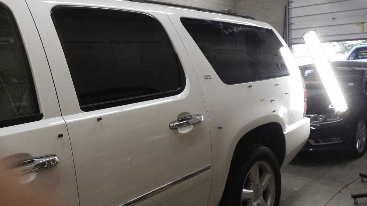 A white suv is parked in a garage with the door open