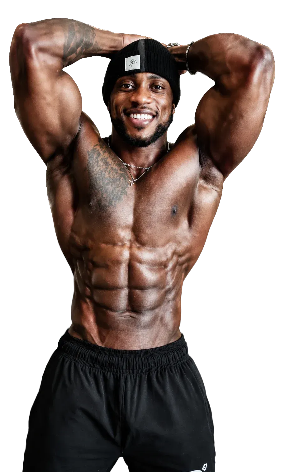 Muscular man posing shirtless in black shorts, hands behind head, against a white background