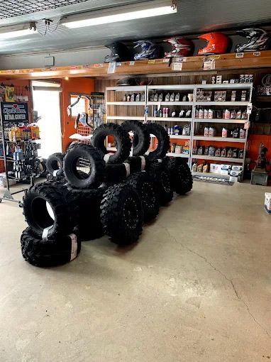 Interior shot of a shop, displaying tires and shelves stocked with merchandise, including helmets.