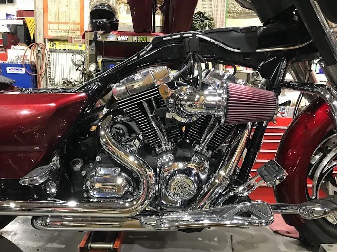 Chrome motorcycle engine with pink air filter on a red bike in a garage
