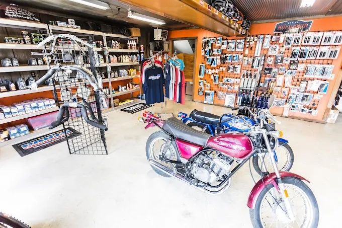 Motorcycle in a shop showroom with racks of parts and accessories in the background
