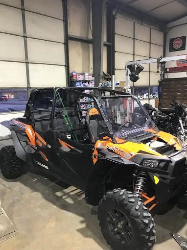 Black and orange off-road side-by-side vehicle parked inside a garage