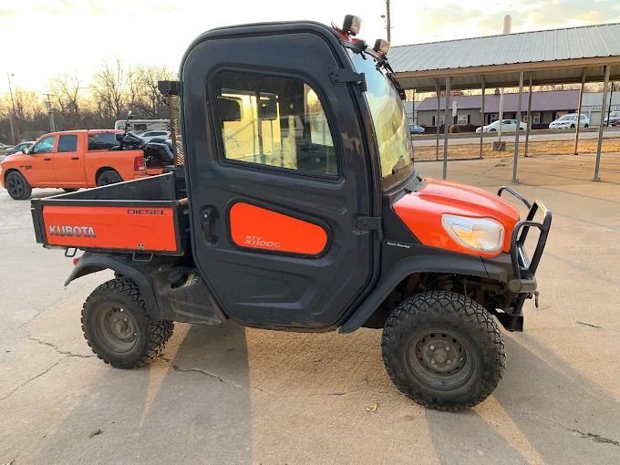 Orange and black utility vehicle parked outdoors on a concrete lot