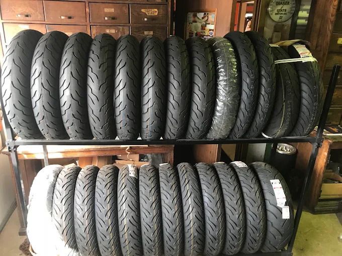 Two rows of black tires stacked on shelves in a garage or workshop