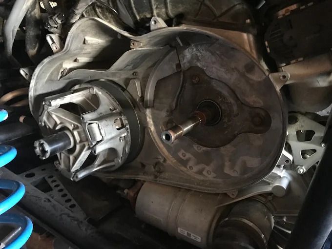 Close-up of a car wheel hub and brake assembly with exposed suspension components underneath.