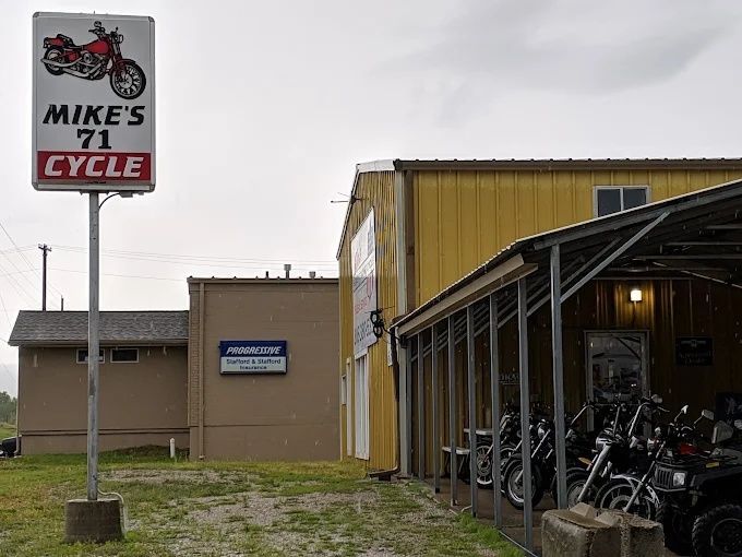 Mike's Cycle storefront with motorcycle sign and bikes displayed under a covered entrance