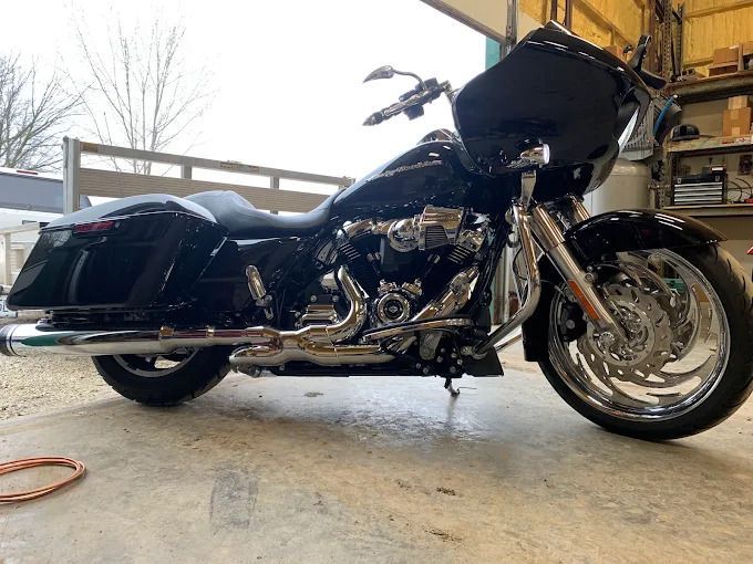 Black touring motorcycle parked in a garage, side view with chrome details and saddlebags