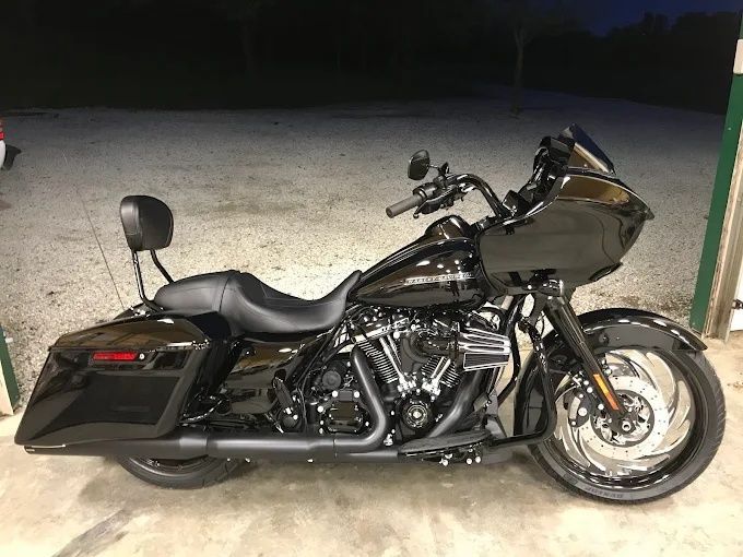 Black touring motorcycle parked on gravel at night with a windshield and saddlebags