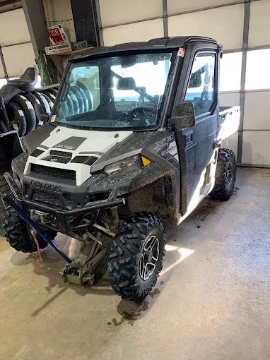 Black-and-white off-road utility vehicle parked inside a garage or workshop