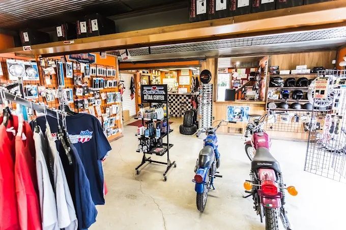 Motorcycle gear shop interior with jackets, accessories, and motorcycles on display