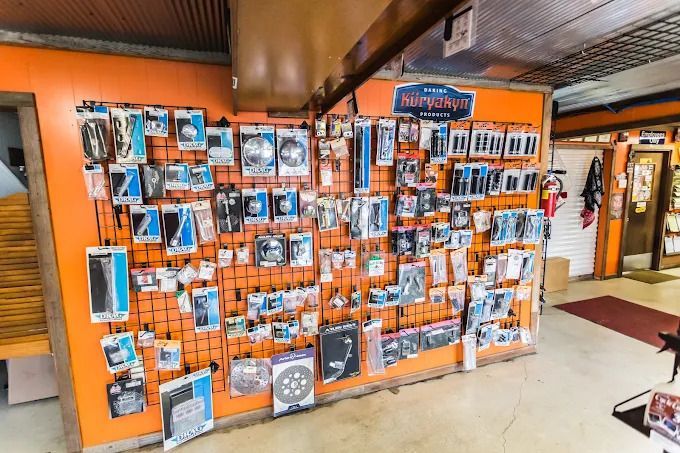 Orange display wall packed with framed photos and cards in a shop interior