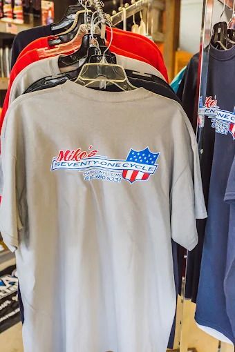Gray Nike T-shirt on a hanger with red, white, and blue graphic in a clothing rack
