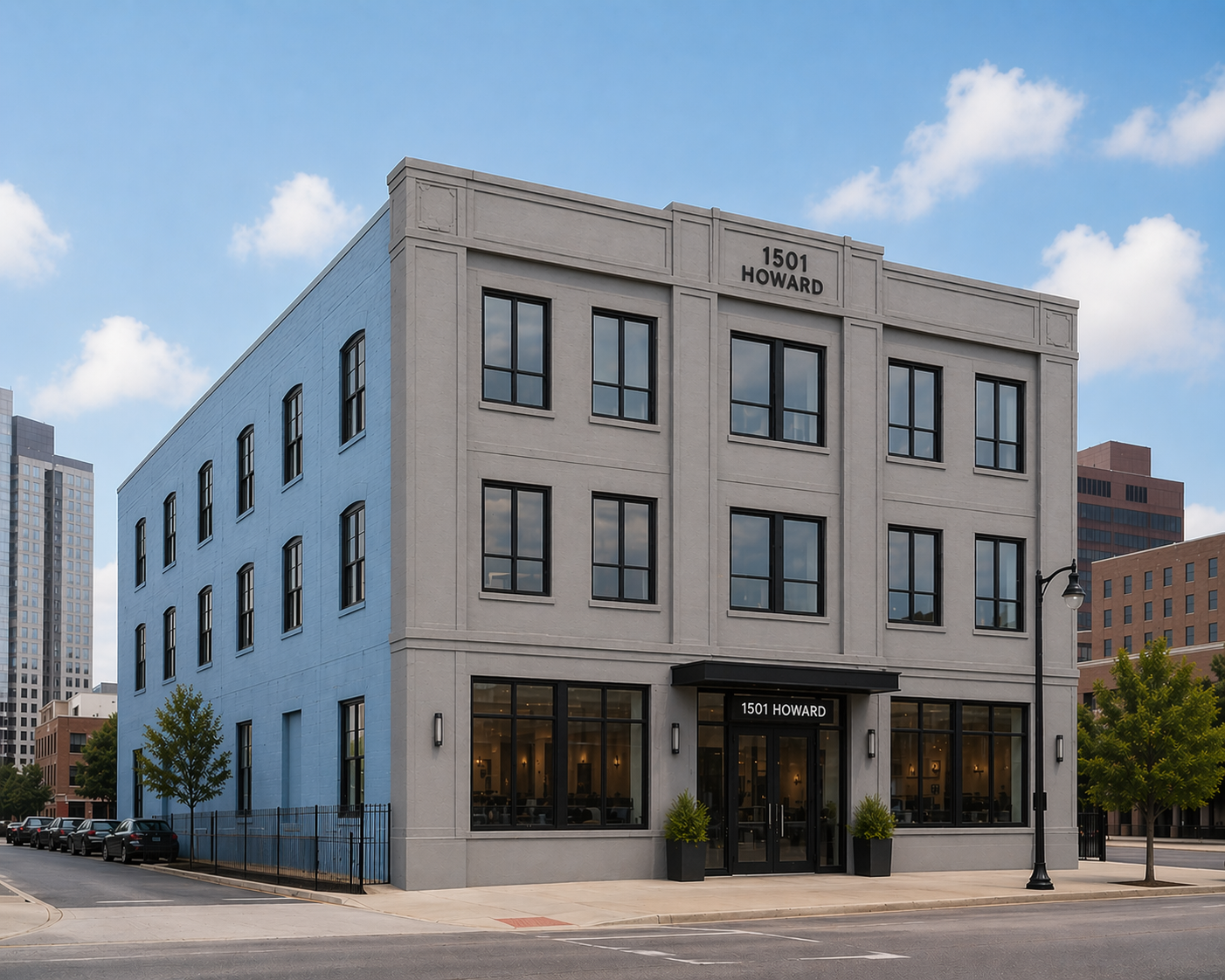 Three-story corner building with light gray facade, black windows, and ground-floor storefronts on a city street.