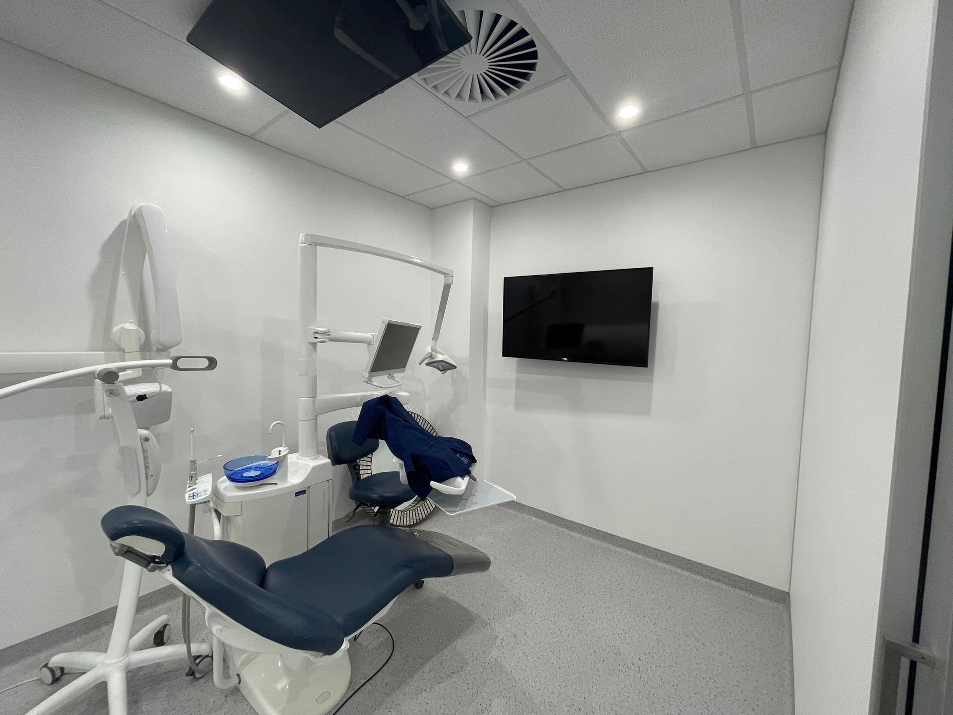 A Clean, Modern Dentist's Exam Room With a Blue Patient Chair — Gray Projects in Woodford, QLD