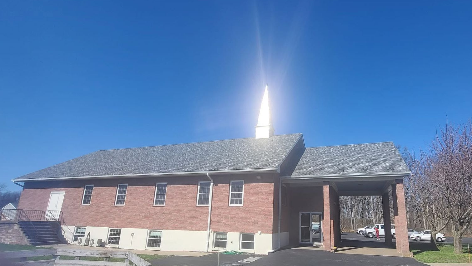 Flat rooftop with dark gray roofing, metal support structure, and distant street view.