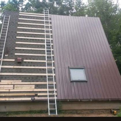Ladder leaning against a partially reroofed house with exposed rafters and brown siding panels