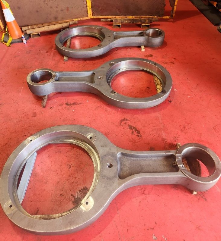 Three pieces of metal are sitting on a red surface