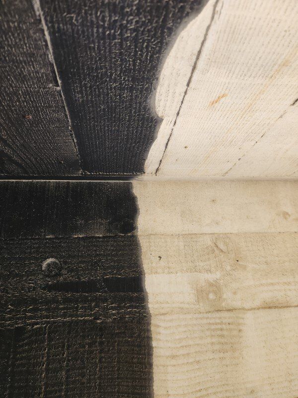 A black and white photo of a wooden wall and floor
