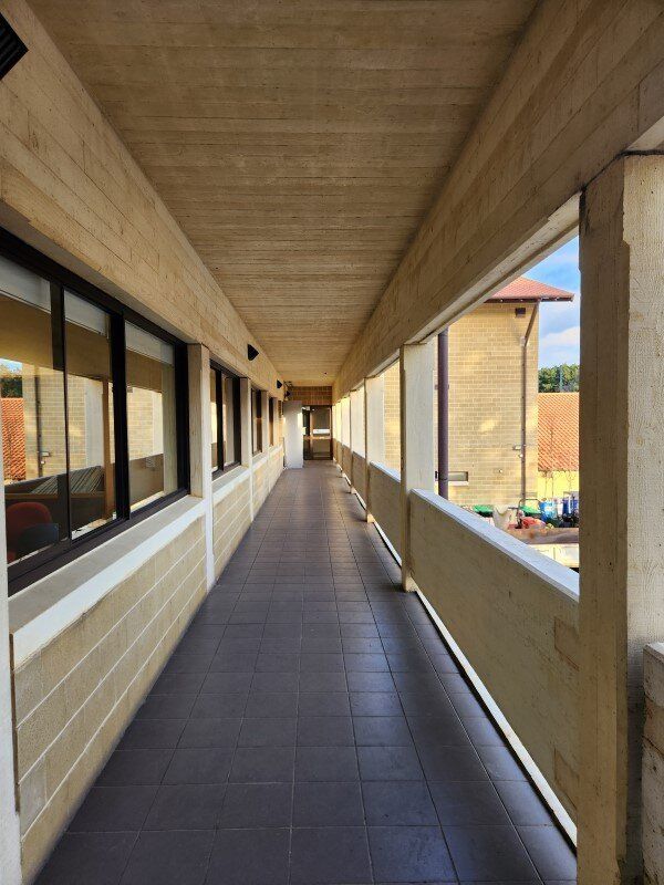 A long hallway in a building with lots of windows